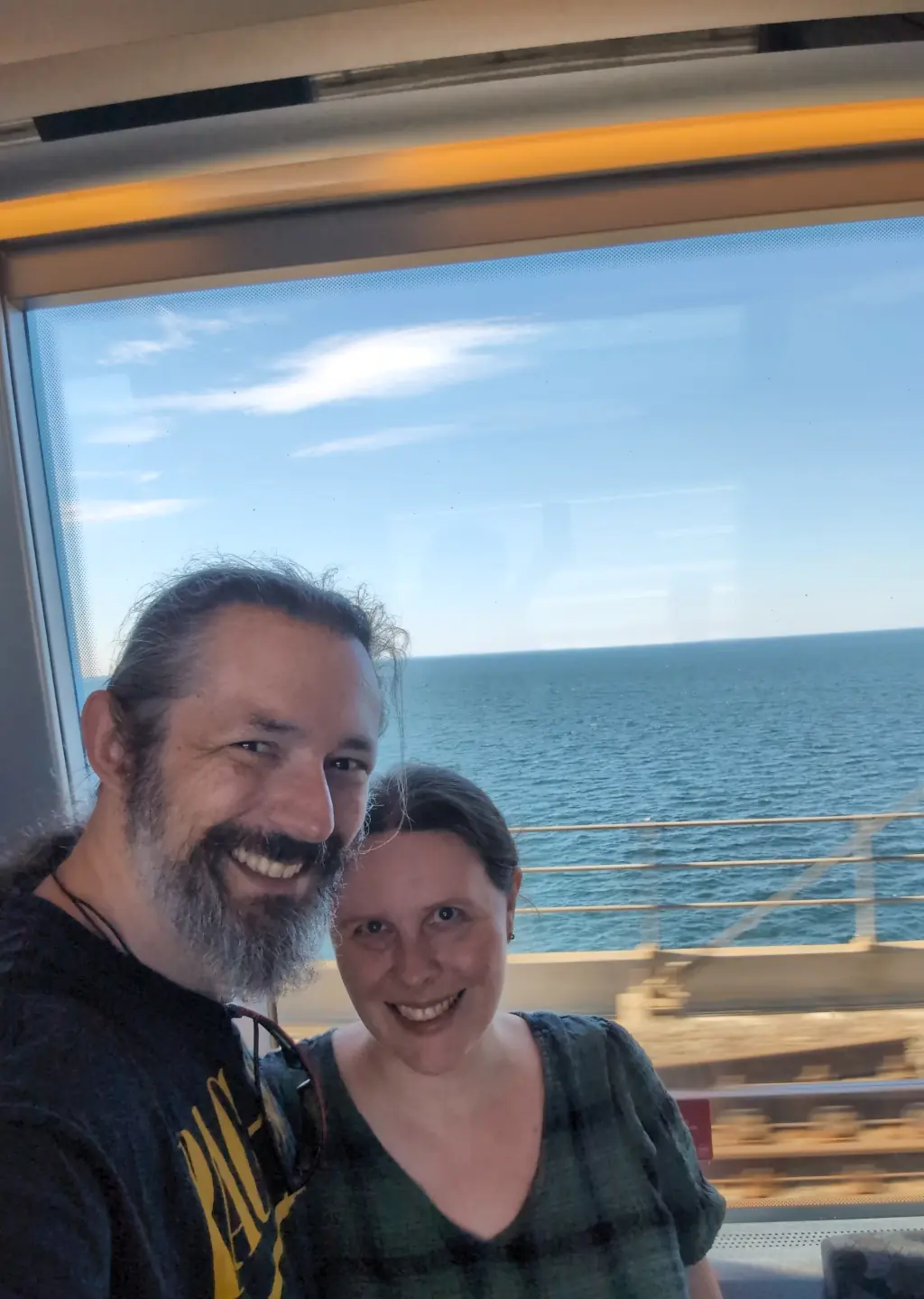 Standing in front of a big window with the water behind us.
