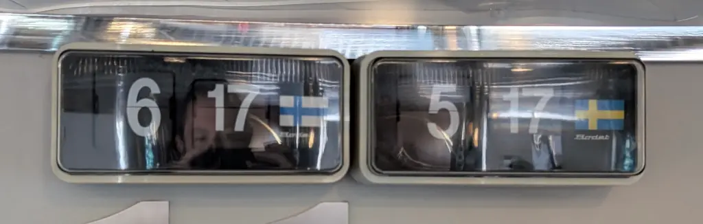 Two clocks. One has a Finnish flag, the other a Swedish flag.