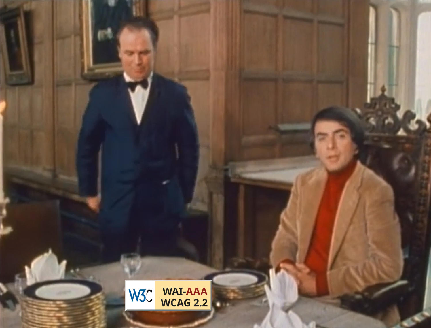 A still from the "Cosmos" TV series, with Carl Sagan seated at a table with an apple pie in front of him. Overlayed on the apple pie is a button reading: "W3C WAI-AAA WCAG 2.2".