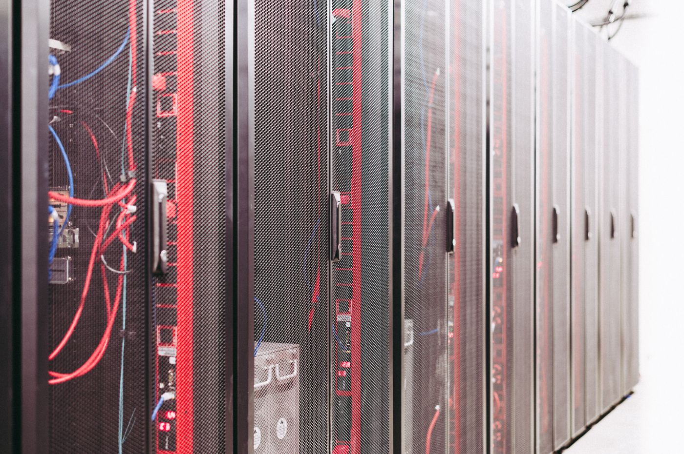 Server rack aisle in a commercial data center — the IRGC's March 2026 drone strikes caused structural damage, fires, and power outages to AWS infrastructure across Bahrain and UAE