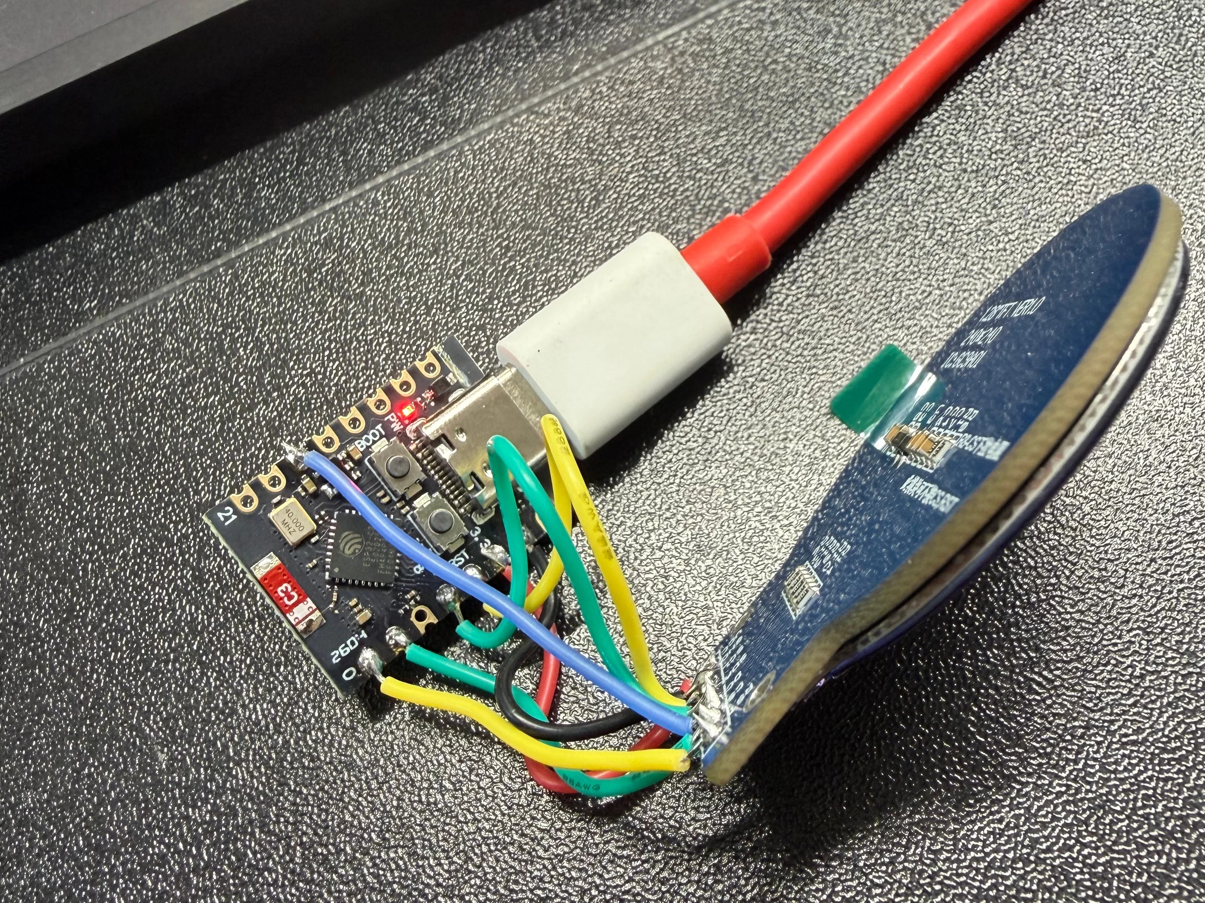 An ESP32-C3 wired to a round display during assembly