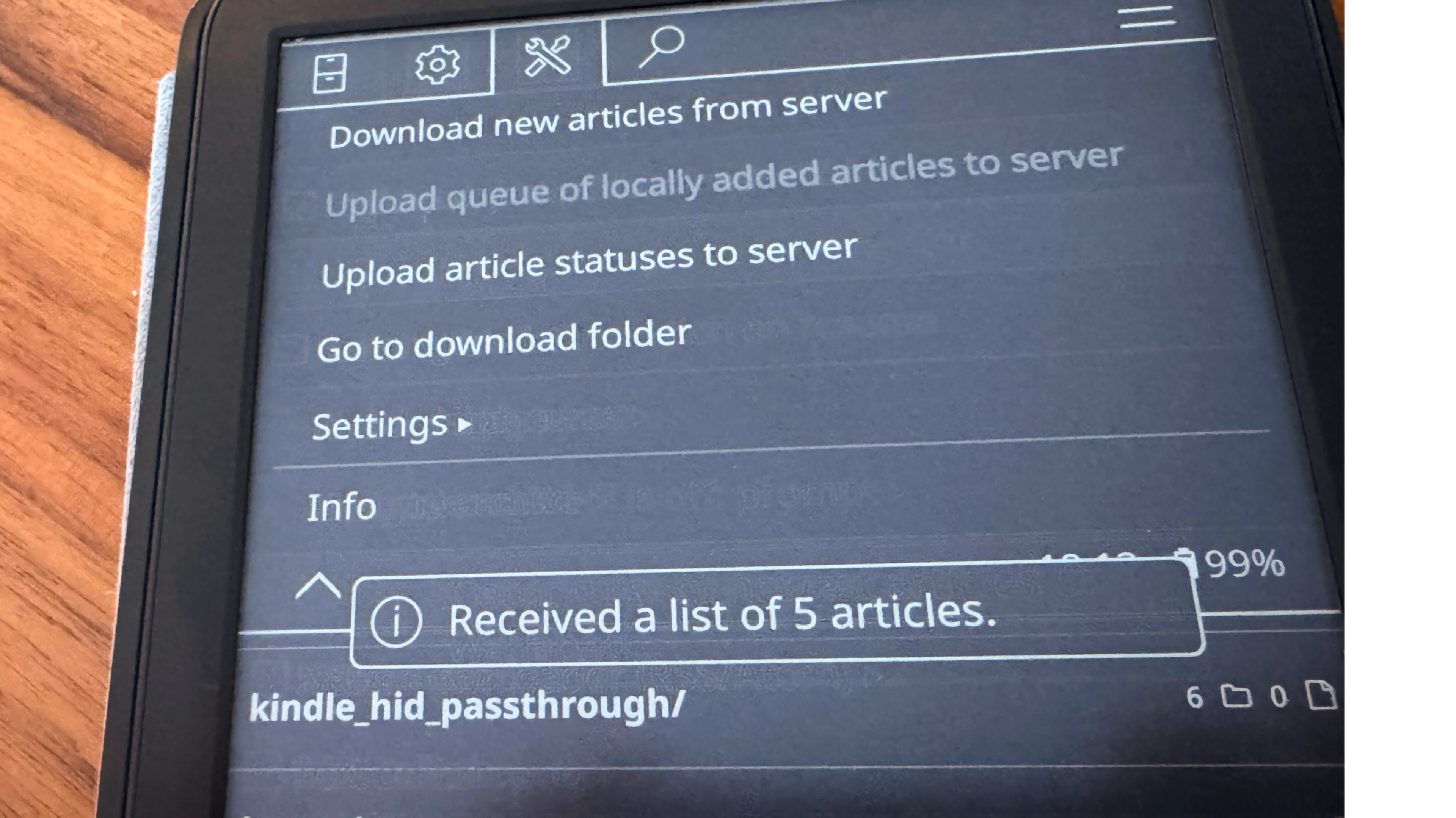 A Kindle, opened to KOReader, with the "Tools" menu selected. On the screen, a toast message reads "Received a list of 5 articles."