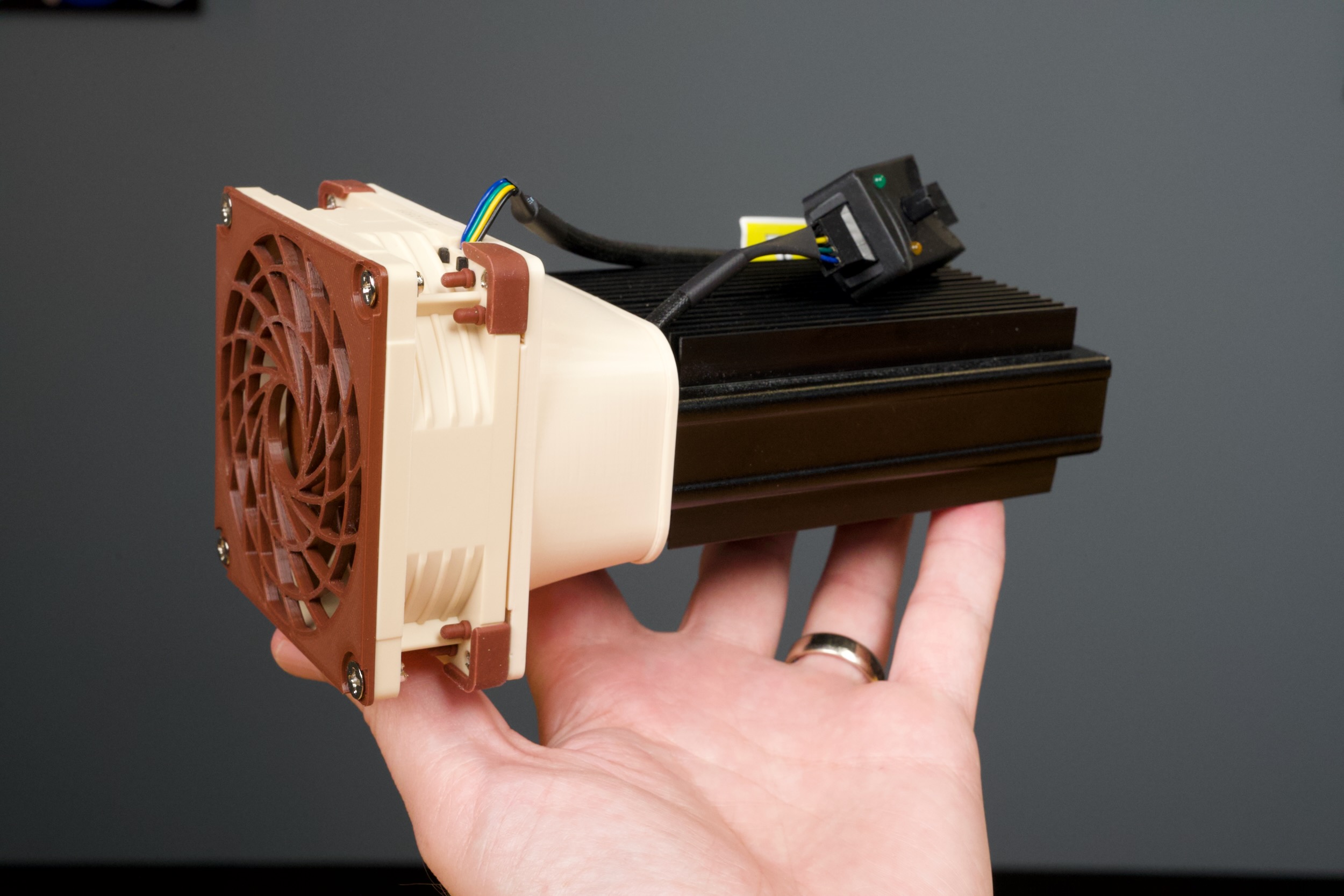Holding the finished NIC with a Noctua 80mm fan and grill cover