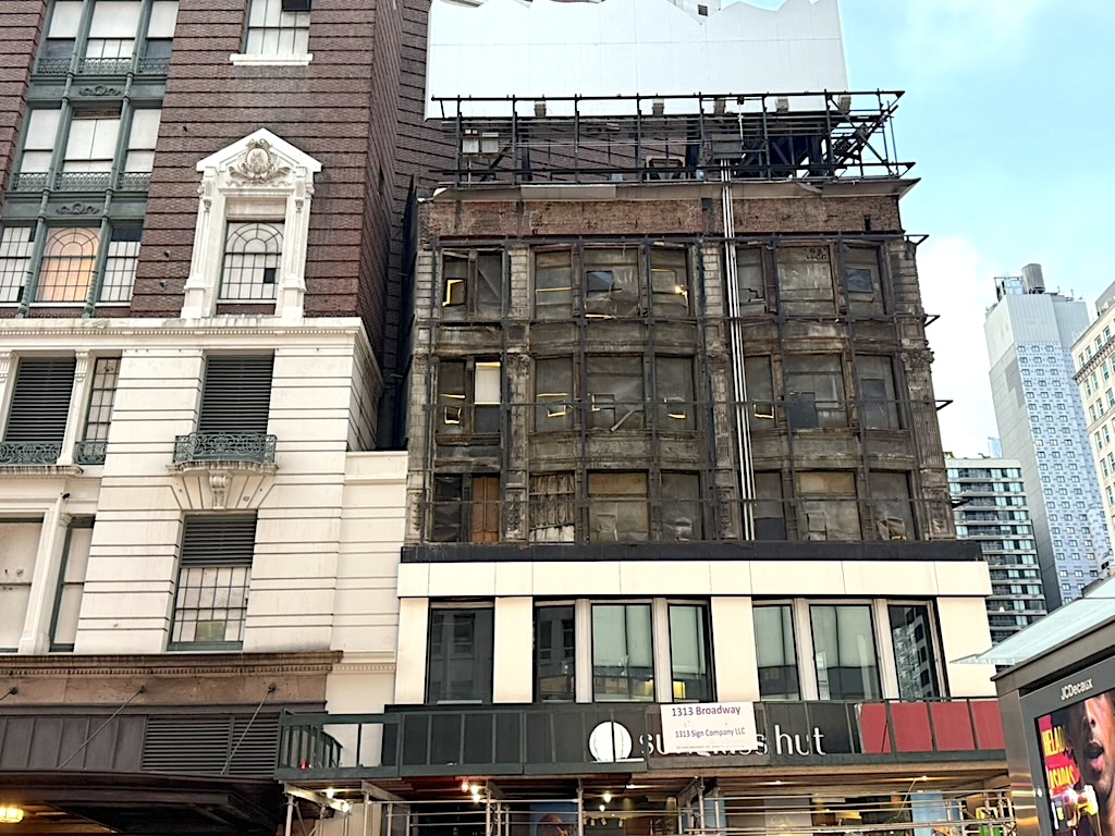 Historical building with a partially renovated facade, showing a contrast between the old brick structure and modern construction scaffolding.