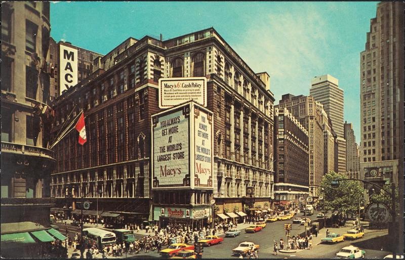 A busy street scene in front of Macy's department store, featuring a large sign advertising 'The World's Largest Store.' Yellow taxis and pedestrians are visible, along with tall buildings in the background.