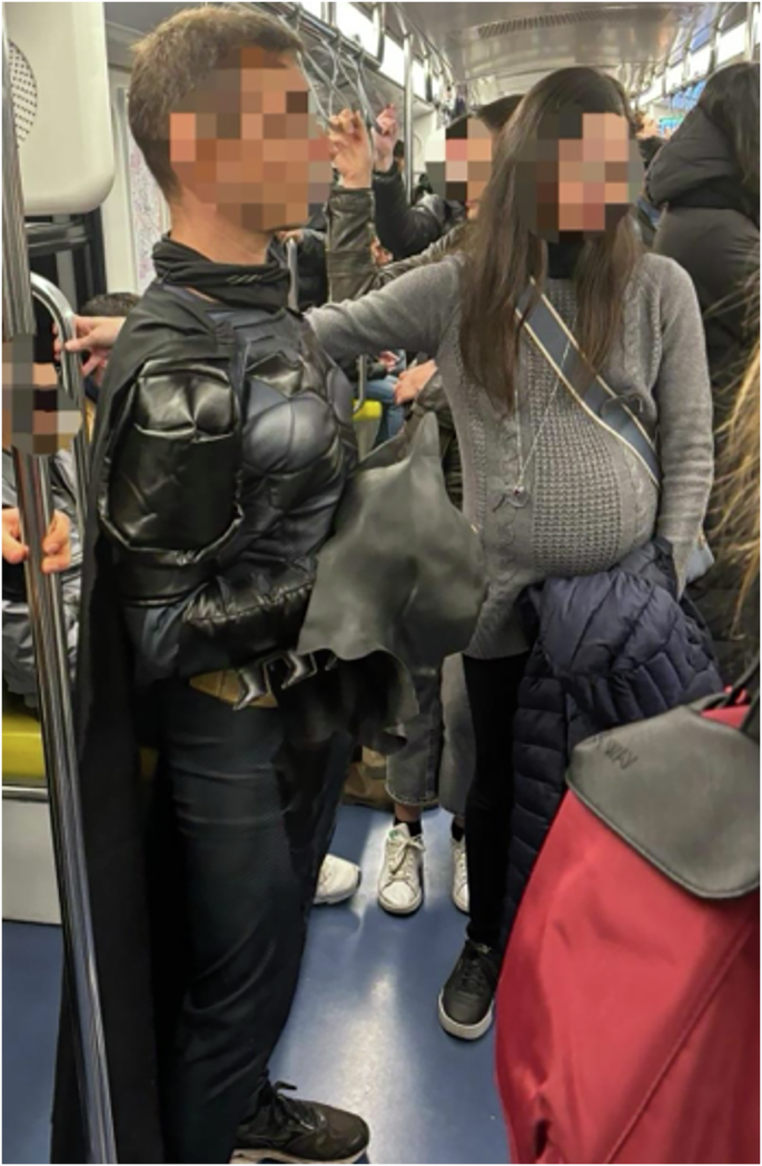 Fig. 1: An example of the experimental setting, with Batman and a woman simulating pregnancy stand in a crowded metro.