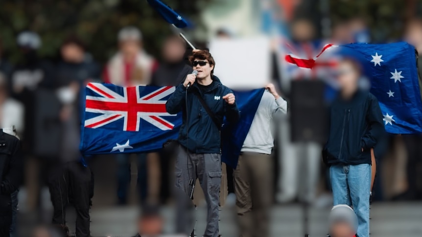 A man with sunglasses stands with other protesters who have been blurred out