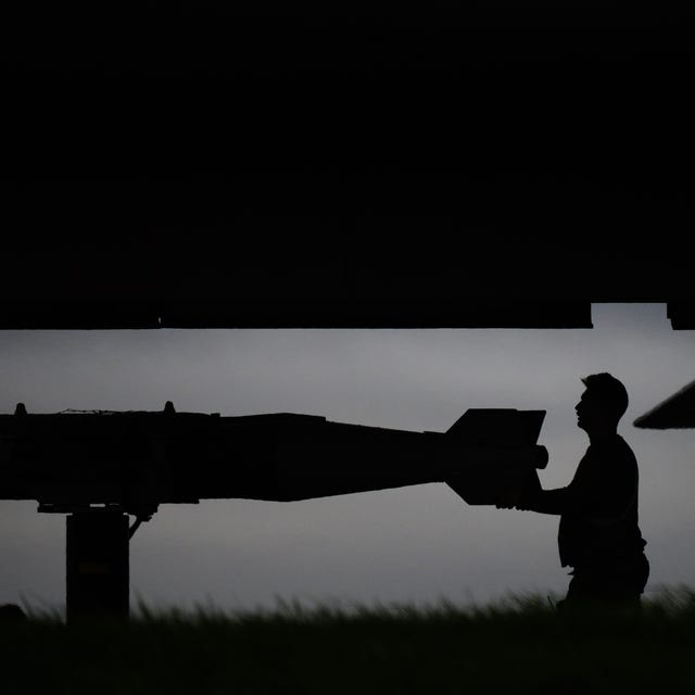 man's silhouette standing behind a missile
