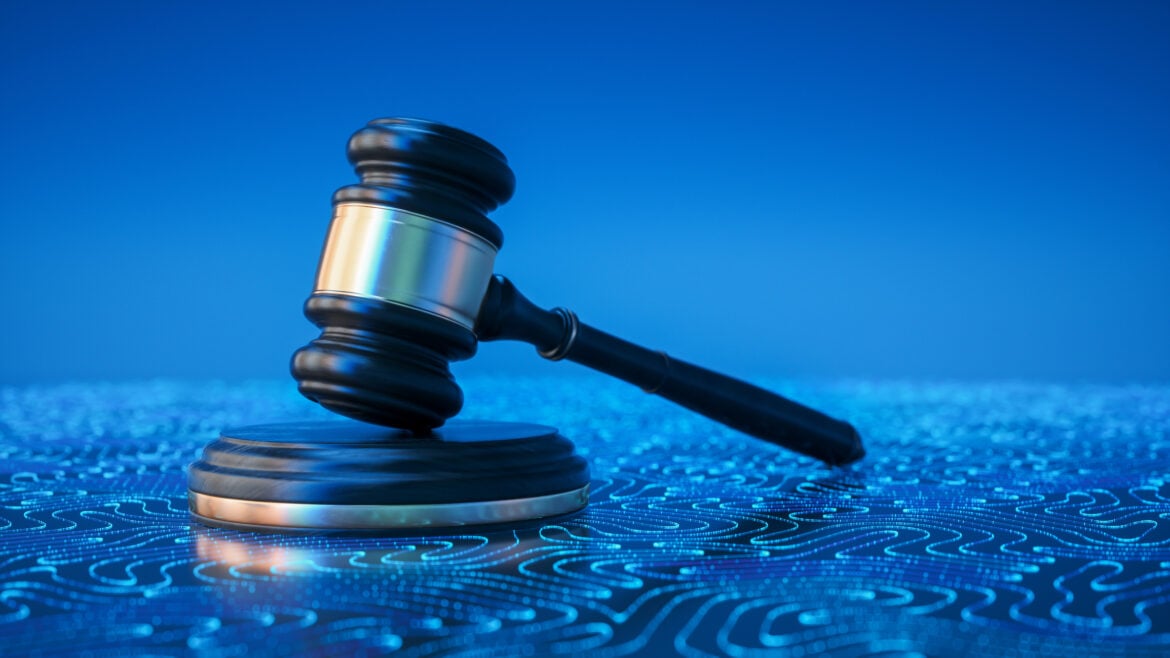 Wooden judge gavel on a blue background with glowing digital circuit patterns