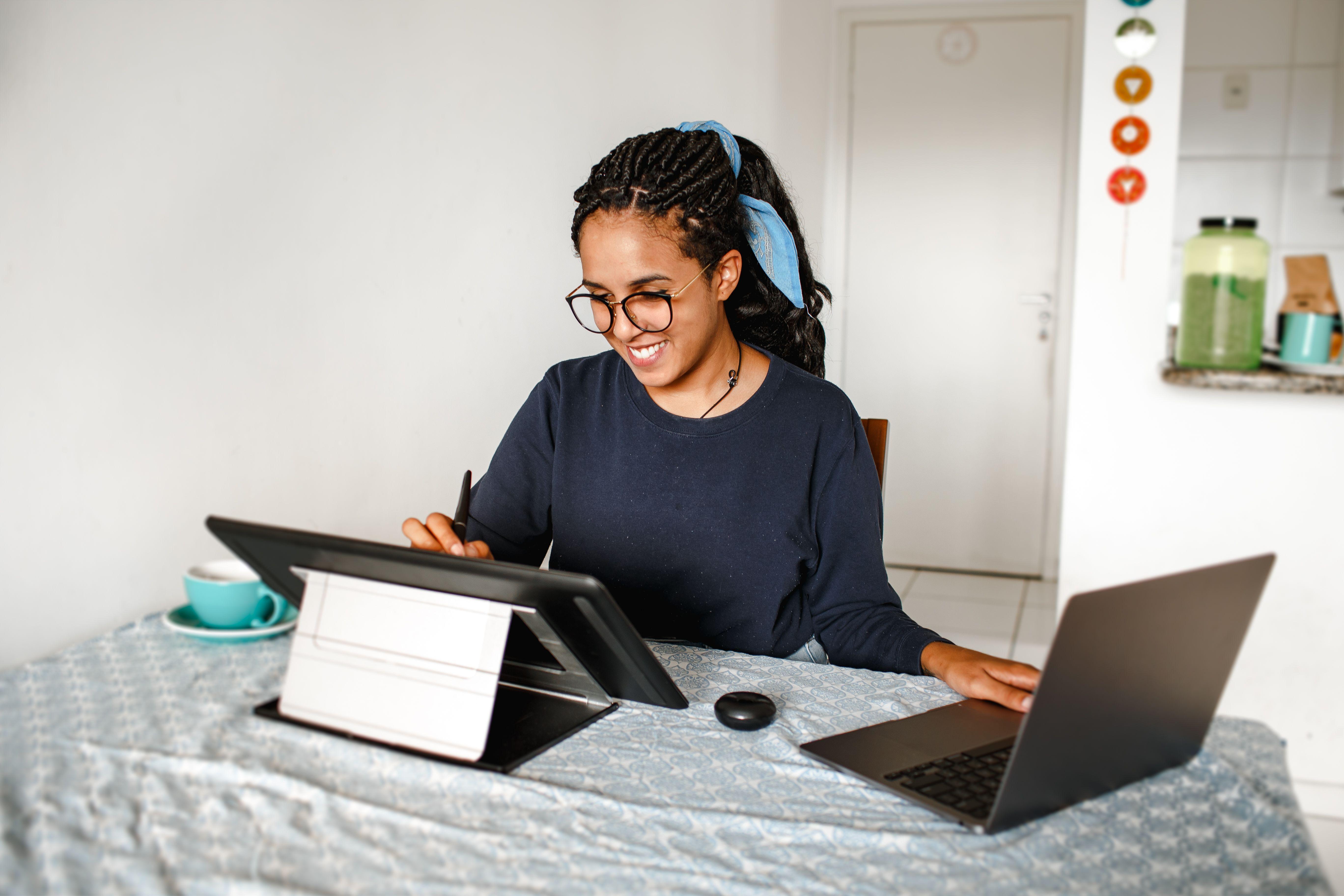 Woman working from her dining room table with two computers