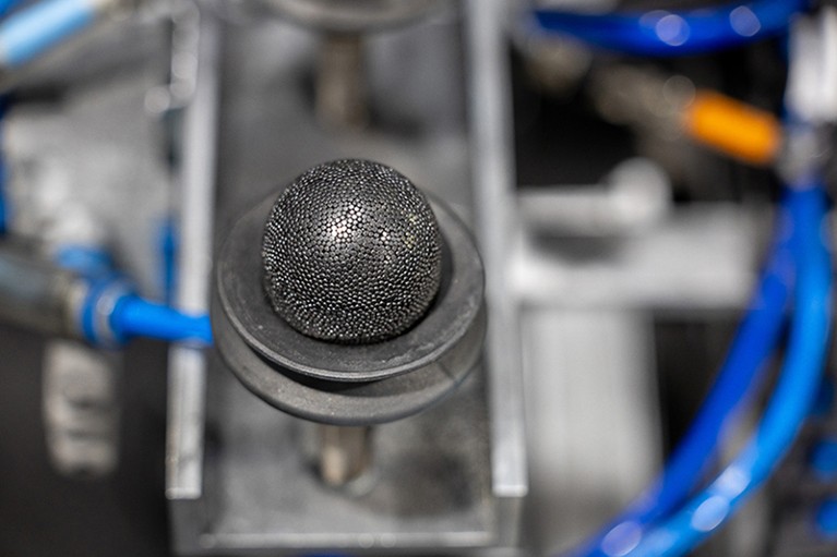 In the foreground a spherical fuel pebble is seen. Background is out of focus.
