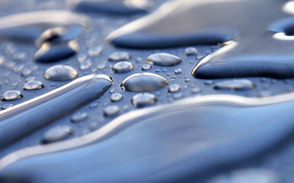Drops of water beading on a metal surface