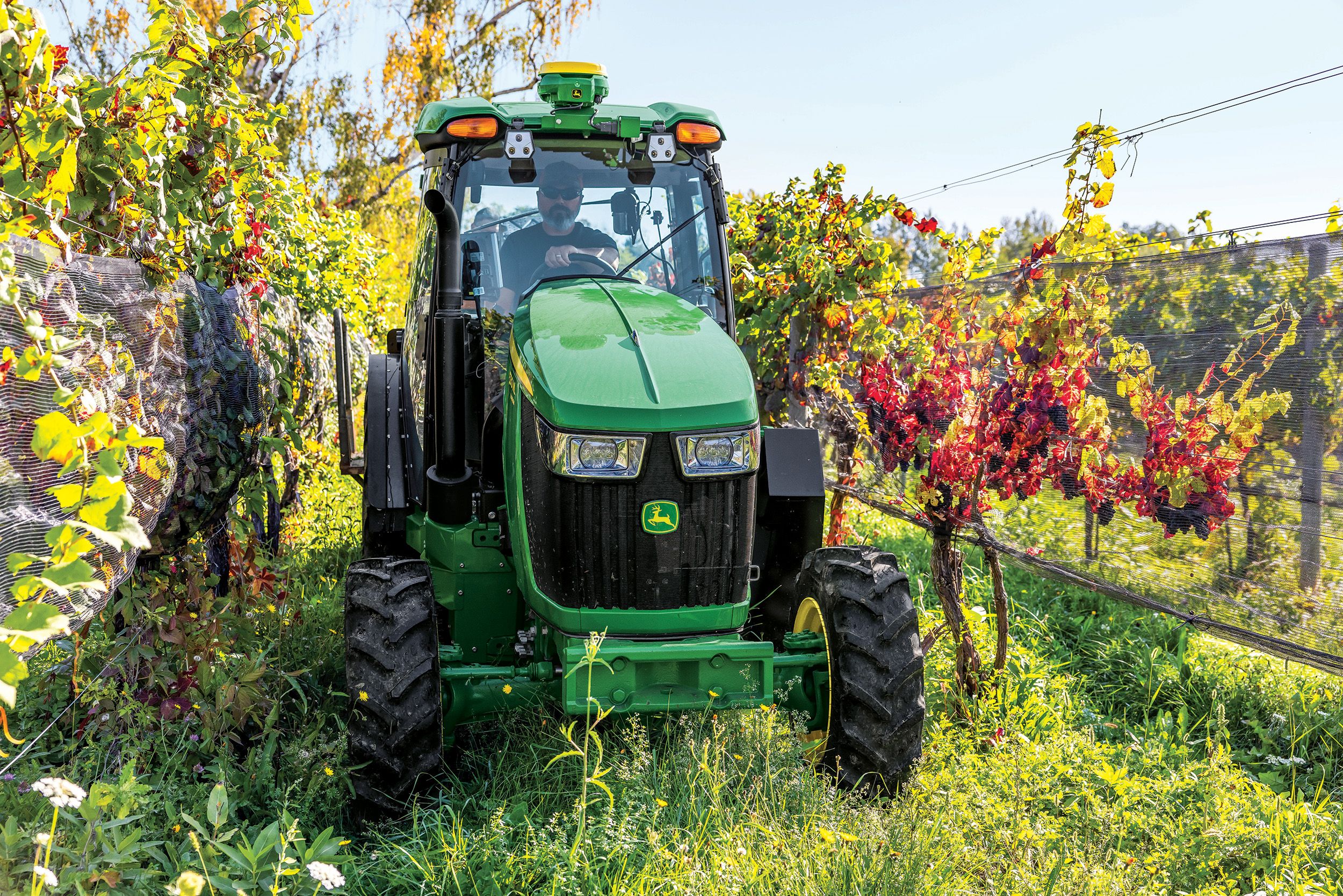 person in john deere tractor in field